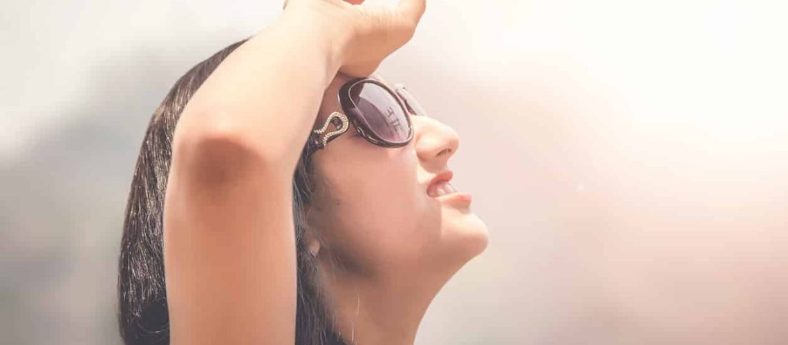 Outdoor summer portrait of young girl in black goggles suffering sun heat